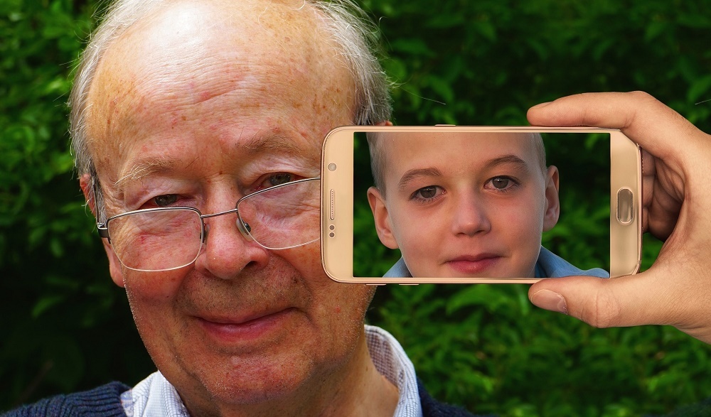 old age man looks like a young boy on phone screen
